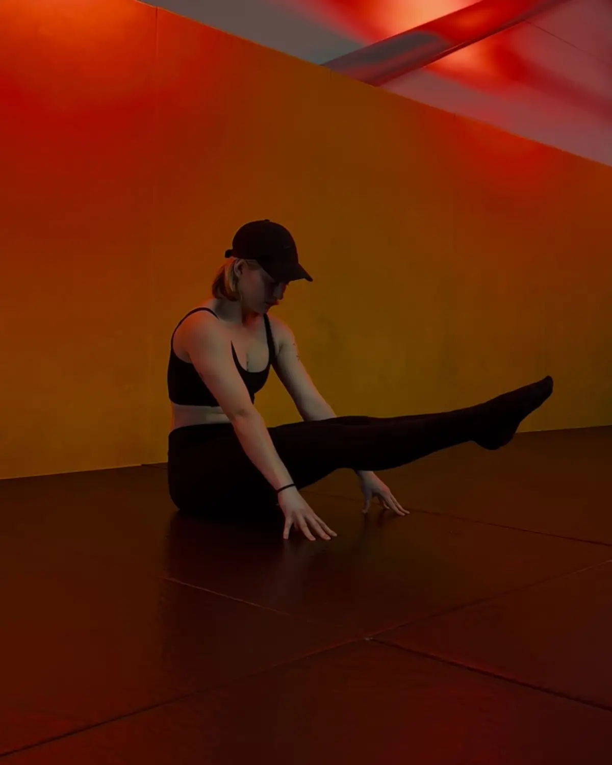 The trainer behind @solid2soul holding a floor position in a warm-lit room