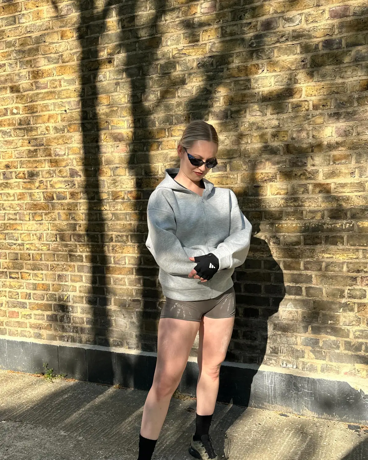The trainer behind @solid2soul by a sunlit brick wall